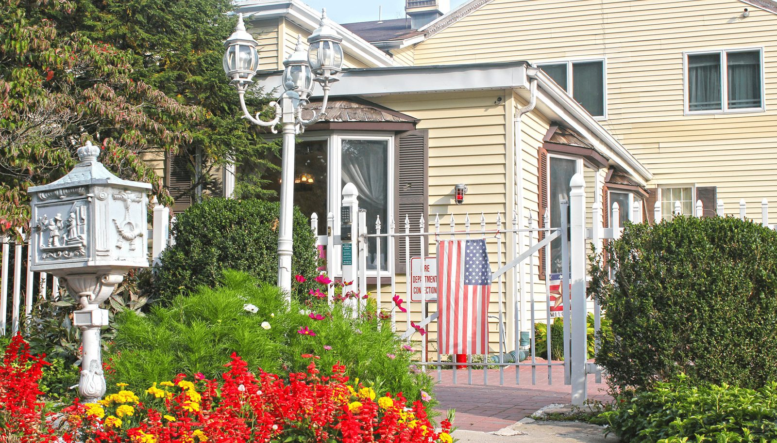 The front walk in summer, lined with red and yellow flowers